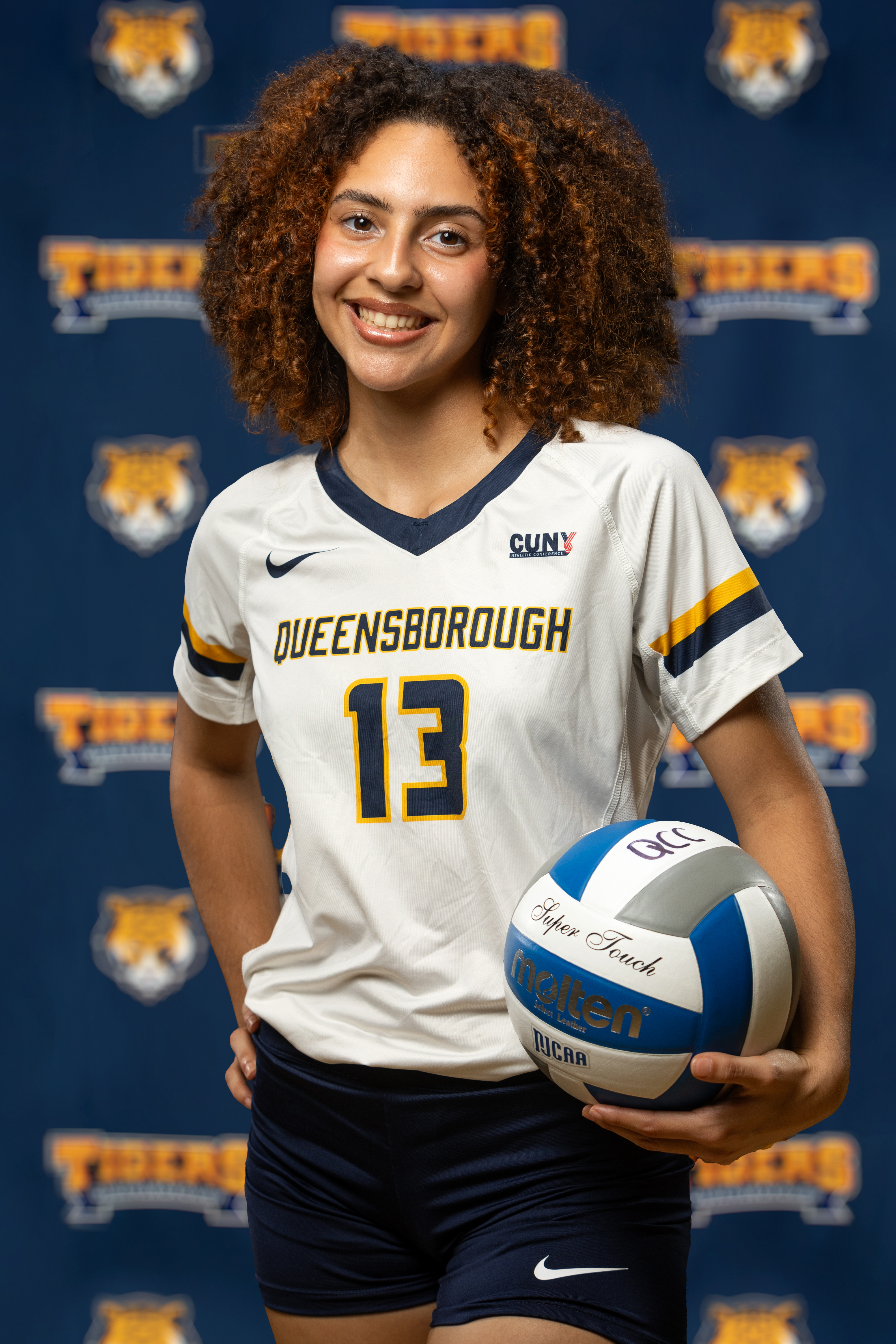 Isabel Torres wearing QCC athletic uniform and holding volleyball